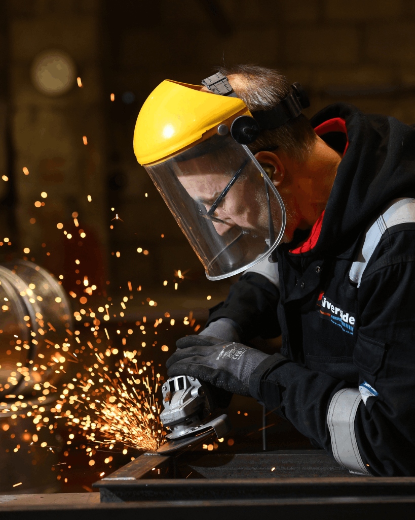A worker welding, demonstrating practical skills